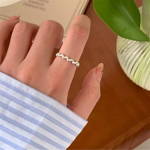 Close-up of minimalist S925 sterling silver beaded ring worn on a finger in a lifestyle setting