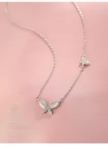 Macro detail of S925 sterling silver butterfly pendant with cat eye stone on pink silk