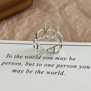 Close-up of geometric hollow chain ring in S925 silver on a minimalist quote card