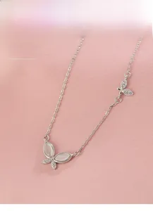 Close-up of S925 silver butterfly pendant with white cat-eye stones and small diamonds
