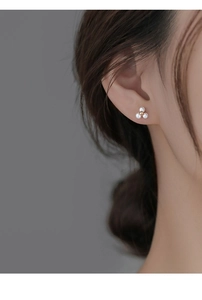 Détail d'un modèle portant d'élégantes boucles d'oreilles trèfle en argent S925