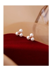 Gros plan sur les boucles d'oreilles en perles S925 en forme de fleur et gravure T