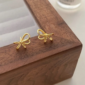 Detailansicht eleganter goldener Schleifen-Ohrstecker mit feinem verdrehtem Liniendesign