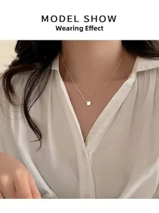 Close-up of minimalist S925 sterling silver cube pendant necklace on a model's neck