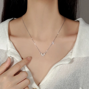 Detail of silver cat-eye stone butterfly necklace on model showing delicate neck fit