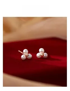 Détail macro de boucles d'oreilles en argent S925 avec perles sur velours rouge
