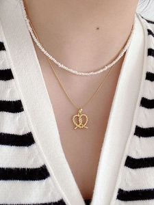 Close-up of S925 silver twist pretzel pendant layered with freshwater pearl necklace