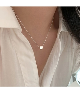 Macro shot of minimalist S925 sterling silver cube pendant on a fine necklace chain