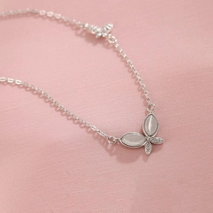 S925 sterling silver butterfly necklace with white cat eye stone on pink silk background