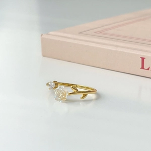 Close-up of gold branch-shaped ring featuring a rose crystal and zircon stone detail