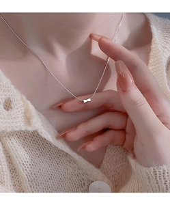 Detailed view of an elegant S925 sterling silver bow pendant necklace worn on neck