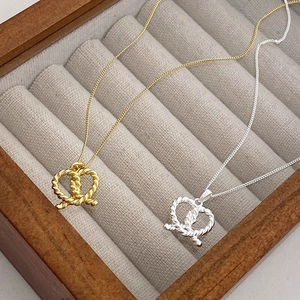 Detailed view of S925 sterling silver twisted knot heart pendant on velvet background