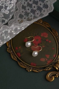 Vue détaillée de boucles d'oreilles en perles d'argent S925 avec crochets dorés