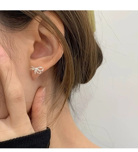 Nahaufnahme von minimalistischem Silber-Schleifen-Ohrstecker am Ohr für eleganten Look