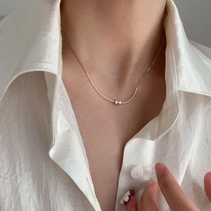 Elegant S925 sterling silver bow necklace shown on model with white satin shirt