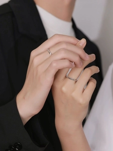 Close-up of elegant Mobius silver rings on fingers showing minimalist twisted design