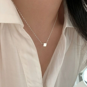 Minimalist S925 sterling silver necklace with a cube pendant worn by a model
