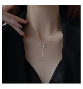 Vue détaillée d'un collier pampille en argent sterling S925 sur le cou d'un modèle