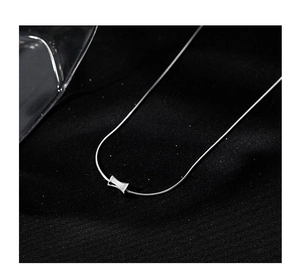 Macro shot of minimalist silver S925 necklace with a modern square pendant on black velvet