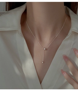 Gros plan d'un collier en argent S925 avec pampille en Y porté sur le cou de femme