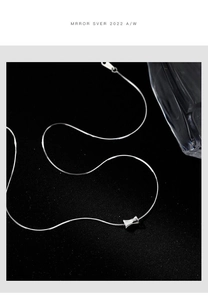 Macro shot of silver cylinder pendant on a sleek snake chain necklace for women