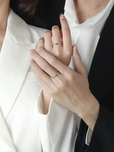Close-up of Mobius silver rings worn by a couple, showing elegant twist and polished finish