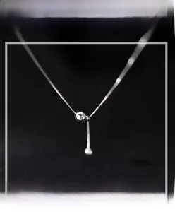 Détail du collier à pampilles en argent sterling S925 sur fond de velours noir