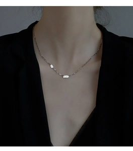 Détail du collier en argent sterling S925 avec pendentif LUCKY porté par un mannequin