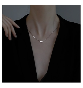 Gros plan du collier en argent S925 avec pendentif carré et inscription LUCKY gravée