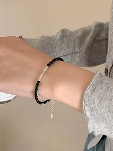 Detail view of S925 silver beaded bracelet with black onyx and heart-shaped pendant on wrist