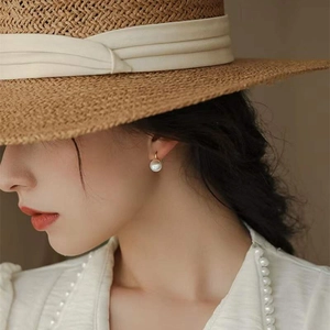 Boucles d'oreilles créoles en argent S925 et perles portées par un mannequin avec chapeau