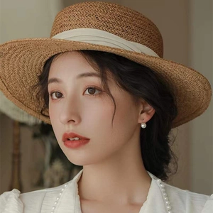 Femme élégante portant des boucles d'oreilles en argent S925, perles d'eau douce et chapeau