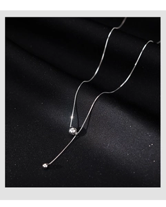 Détail macro d'une chaîne en argent S925 avec pendentifs en perles lisses et pampilles