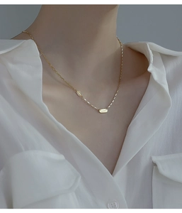 Détail de pendentifs Lucky dorés sur une fine chaîne de collier en argent S925