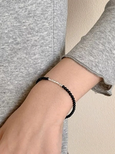 Detail of S925 silver beaded bracelet with black onyx stones on a female wrist