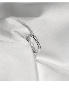 Dettaglio dell'anello in argento S925 con linee intrecciate e punzonatura incisa