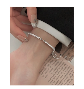 Detailed view of polished S925 sterling silver bead bracelet with adjustable chain on wrist