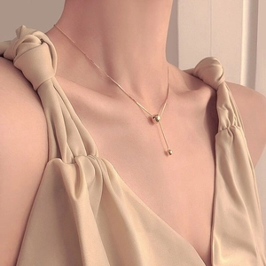 Collier élégant en argent S925 doré avec perles à pampilles porté au cou au style épuré