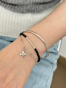 Detail of S925 sterling silver layered bracelet set with black beads and cross pendant