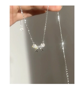 Dettaglio del marchio S925 argento e del ciondolo a fiocco scintillante con zirconi