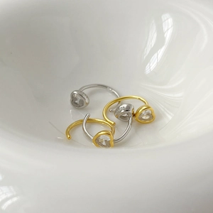 Gros plan de boucles d'oreilles cœur en argent S925 avec zircons dans un bol blanc