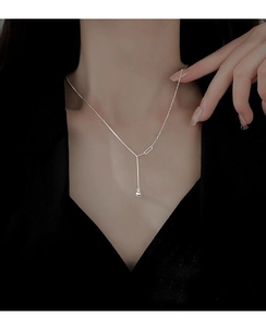 Detail of S925 sterling silver Y-shaped tassel necklace with polished bead pendant on model