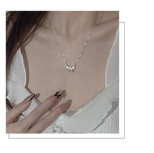 Vista dettagliata di una collana con ciondolo a fiocco in argento S925 sulla clavicola