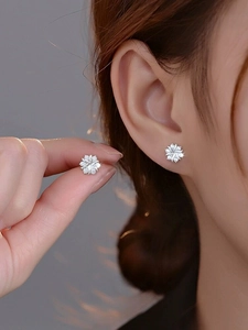 Macro shot of S925 sterling silver snowflake stud earrings with sparkling cubic zirconia