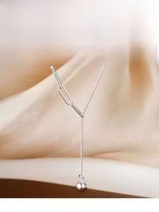 Detail of S925 sterling silver Y-shaped tassel necklace with polished bead on silk fabric