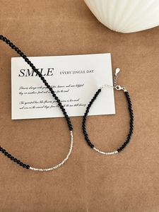 Macro detail of S925 sterling silver stamp on black onyx beaded necklace and bracelet