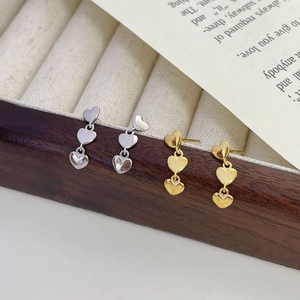Détail de boucles d'oreilles triple cœur en argent S925 finitions dorée et argentée