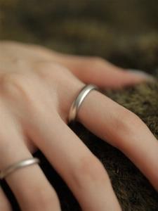 Macro detail of a minimalist S925 sterling silver ring with a matte brushed texture finish