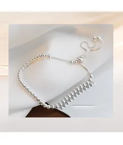 Detail of adjustable S925 sterling silver ball bracelet on white textured cloth