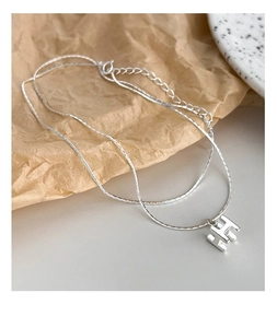 Détail macro du collier en argent S925 avec pendentif lettre H 3D et fine chaîne double